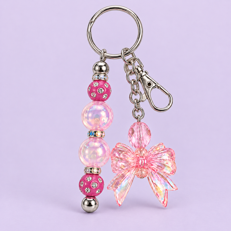 Pink beaded bow keychain on a dark lavender background